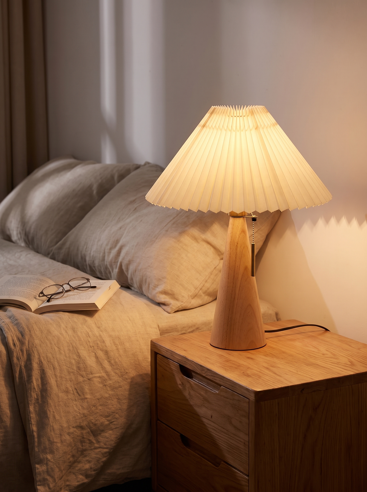 Pleated wooden table lamp on bedside table