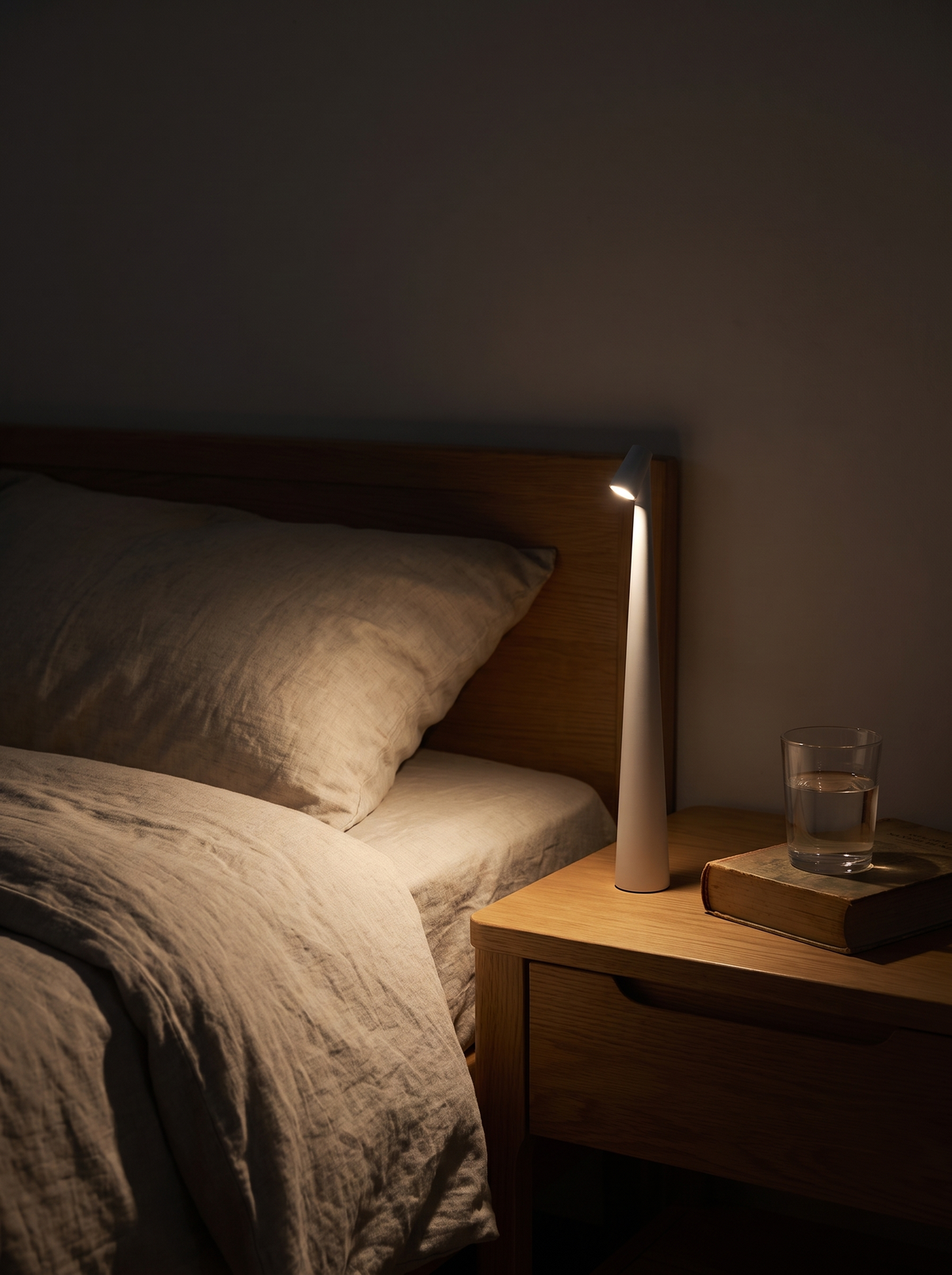 Slim rechargeable LED lamp on a bedside table