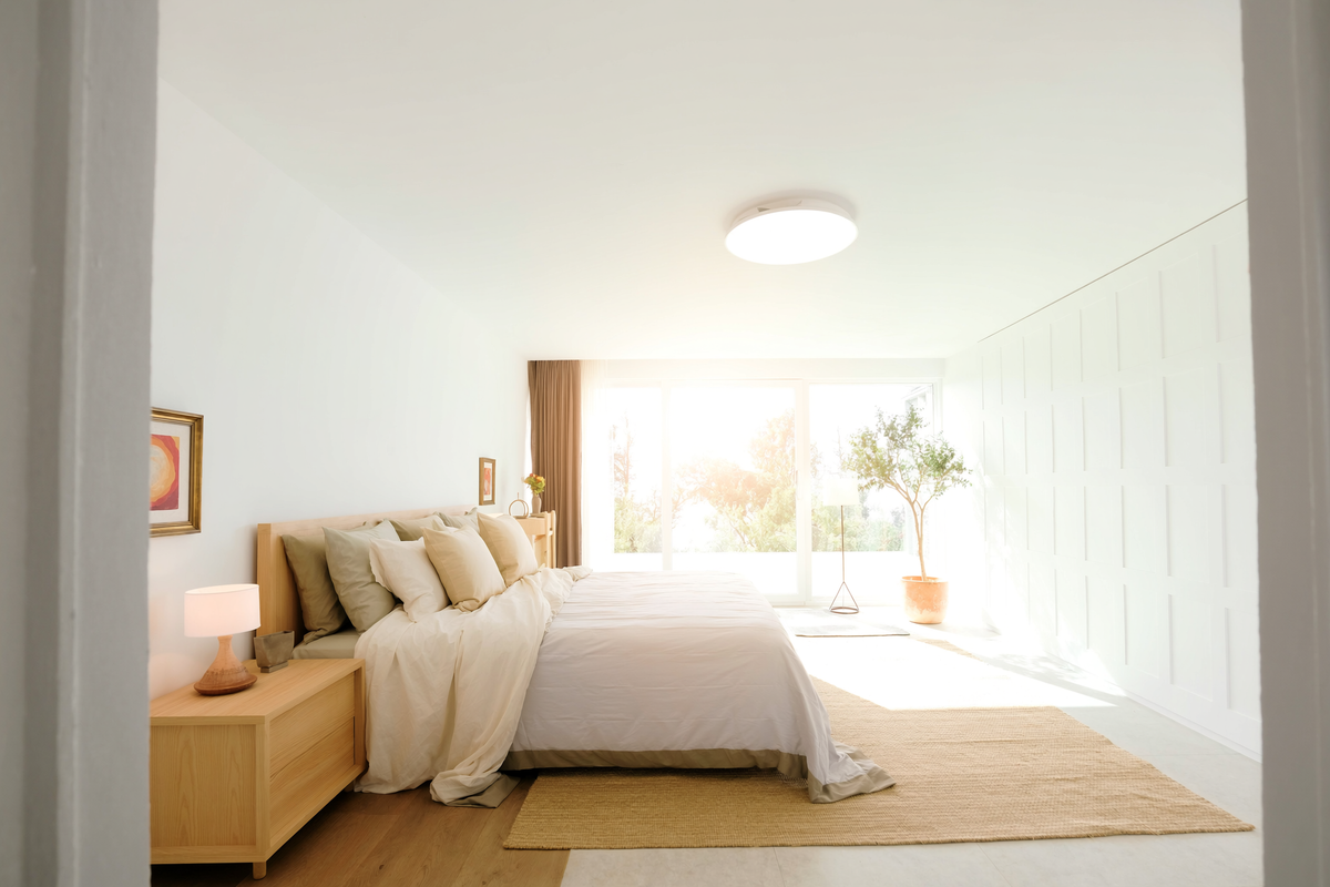 Flush mount ceiling light in a sunlit modern bedroom